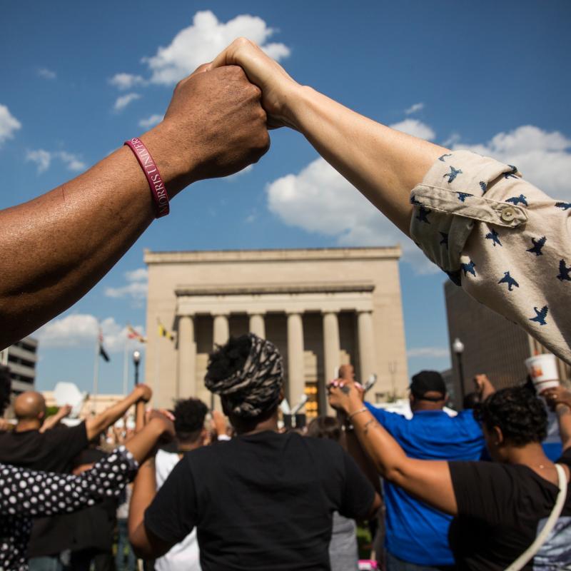 People holding hands at a rally