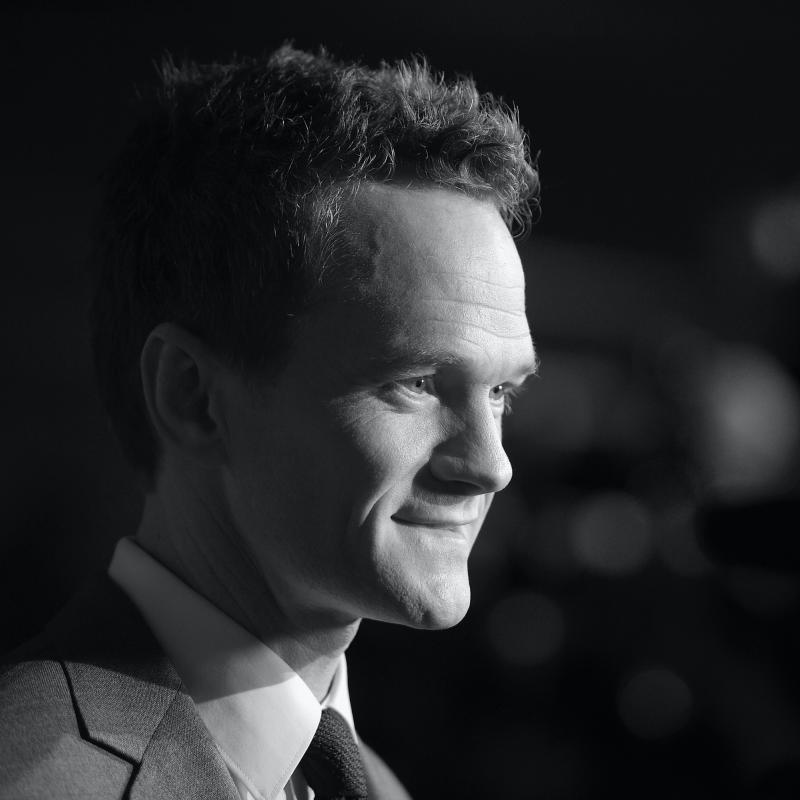 Actor Neil Patrick Harris looks away from the camera in a candid black and white portrait.