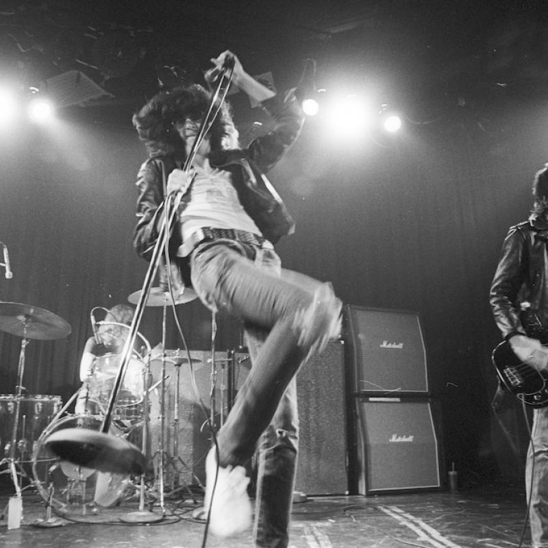 Joey Ramone performing on stage with his band The Ramones
