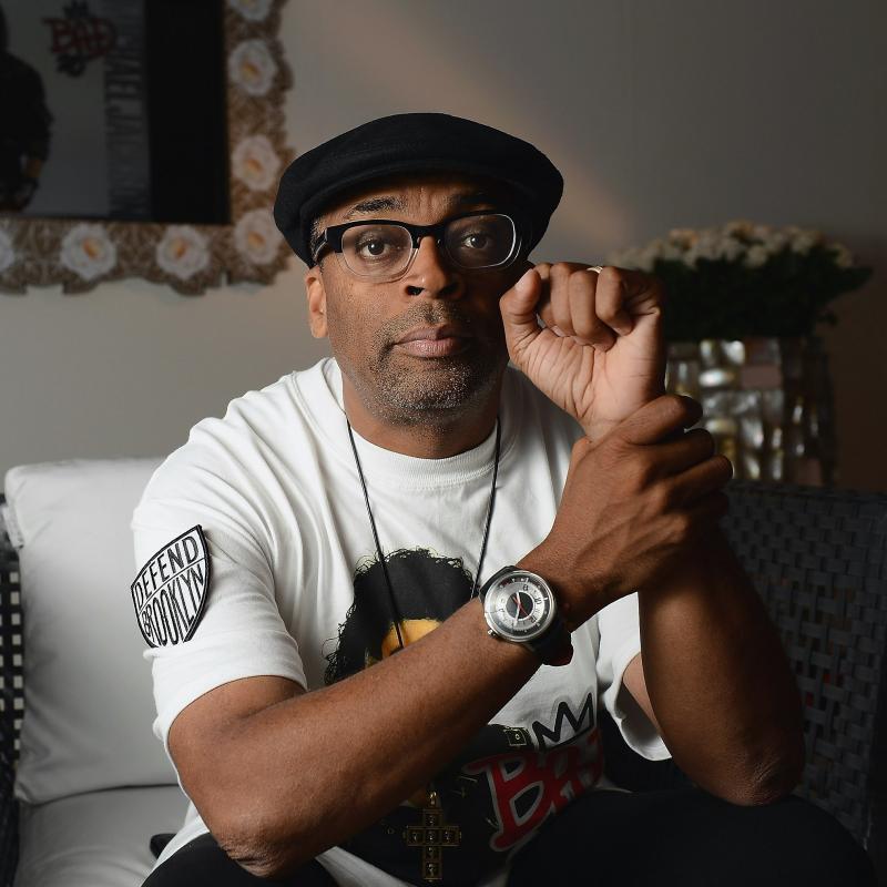 Film director Spike Lee poses with a fist raised while staring at the camera for a portrait
