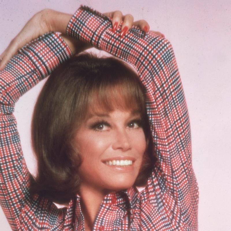 Actress Mary Tyler Moore poses with her arms folded over her head in this photo from 1975