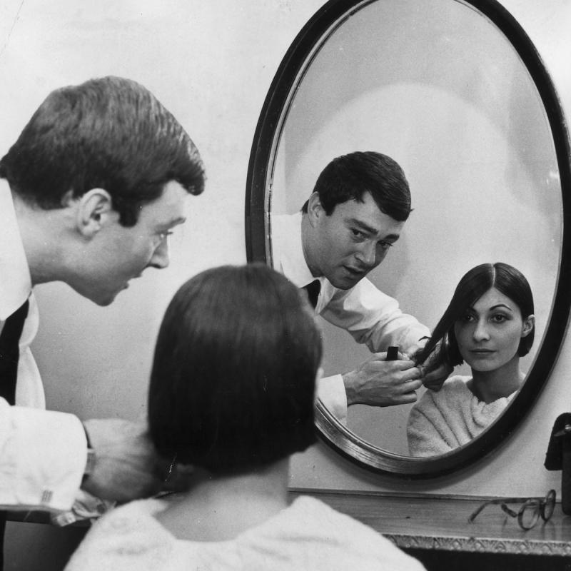 British hairdresser Vidal Sassoon cuts a woman's hair